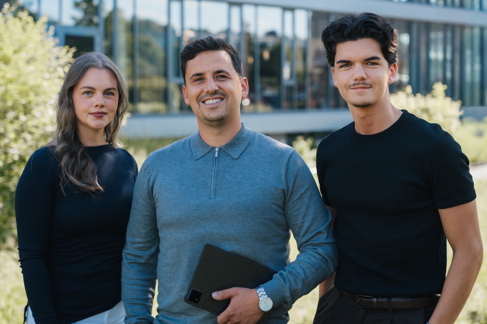 Stefan Schmunk mit seinem Team vor einem modernen Bürogebäude